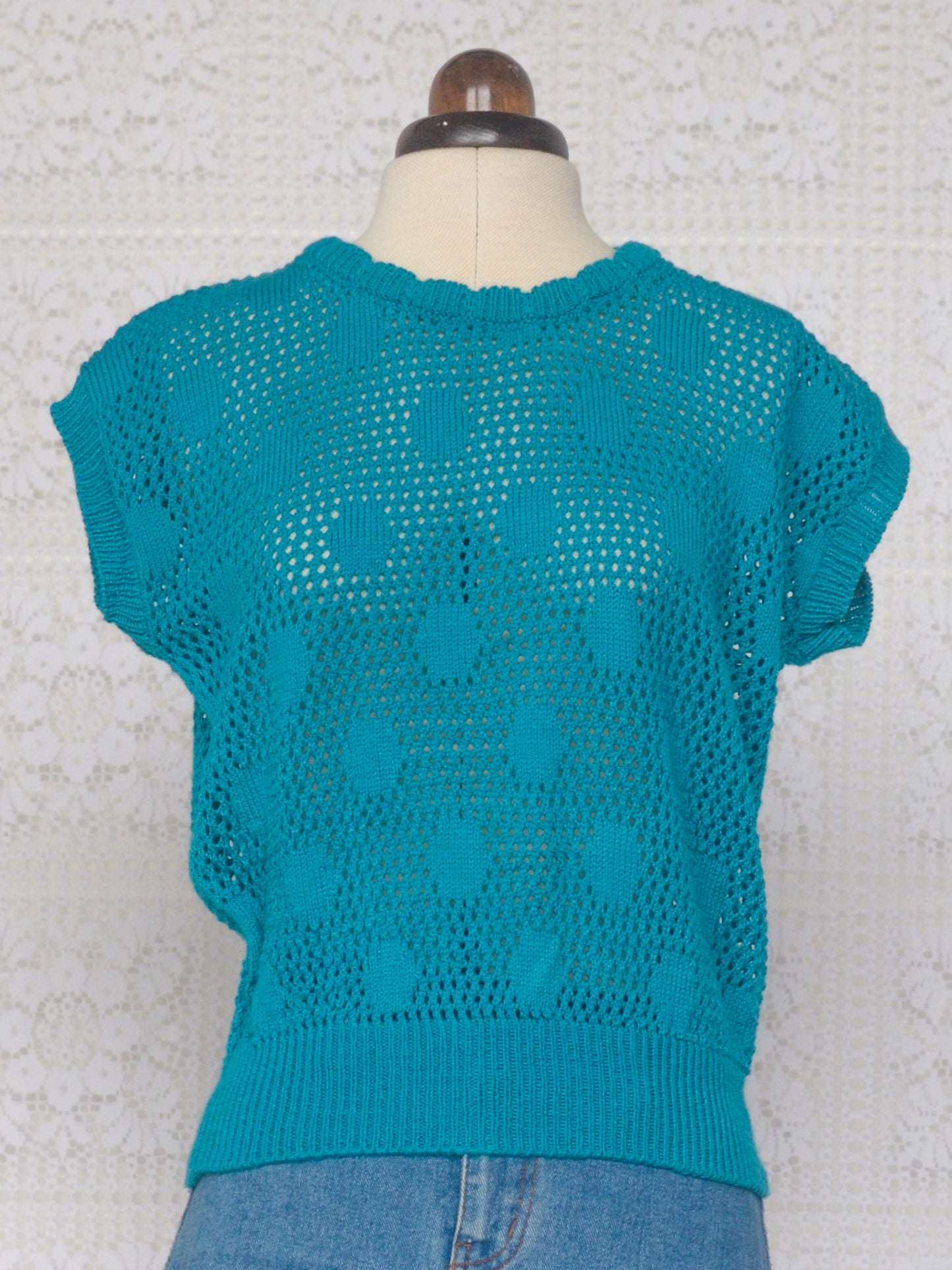 1980s style teal knitted sleeveless jumper with polkadot pattern