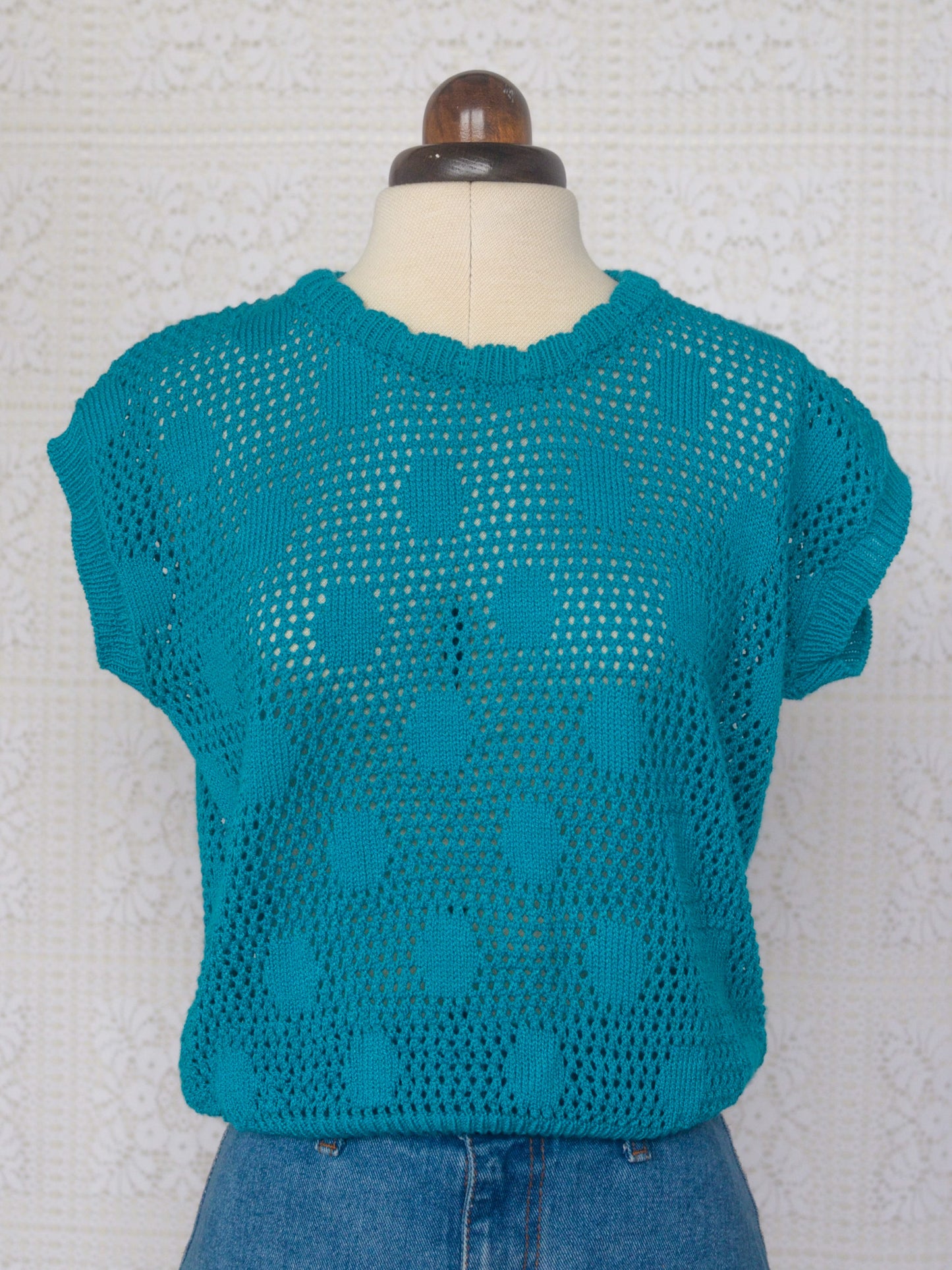 1980s style teal knitted sleeveless jumper with polkadot pattern